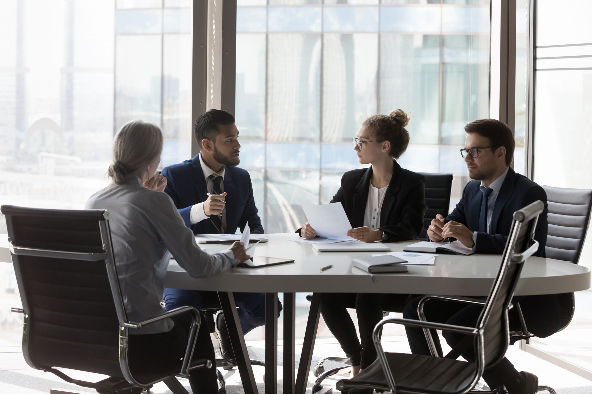 Ocupado grupo profesional millennial revisando informes de marketing de startups